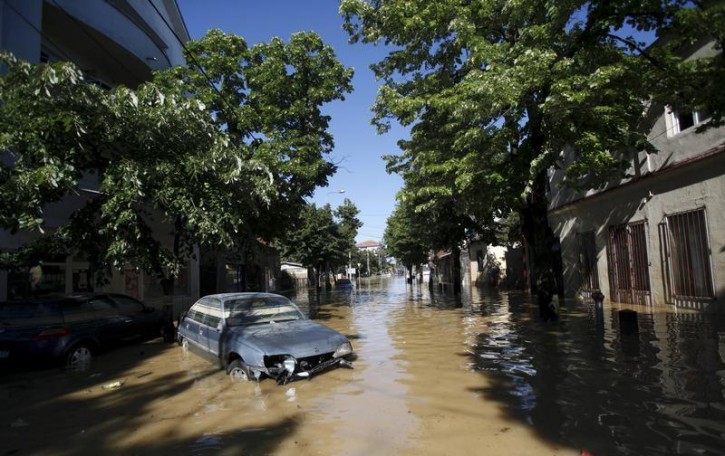 A damaged car is seen stranded in flood waters in the town of Obrenovac, southwest of Belgrade, May 19, 2014. Soldiers and energy workers stacked thousands of sandbags overnight to protect Serbia's biggest power plant from flood waters expected to keep rising after the heaviest rains in the Balkans in more than a century killed dozens of people. REUTERS/Antonio Bronic