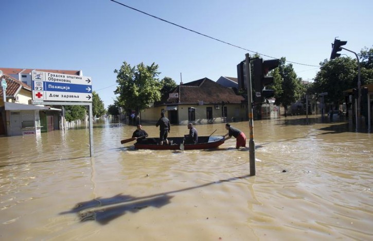 Local people travel on a boat in the flooded town of Obrenovac, southwest of Belgrade, May 19, 2014. Communities in Serbia and Bosnia battled to protect towns and power plants on Monday from rising flood waters and landslides that have devastated swathes of both countries and killed dozens of people. REUTERS/Antonio Bronic 