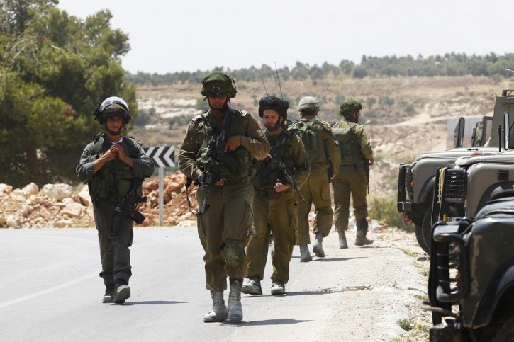 Israeli soldiers patrol near the West Bank city of Hebron June 13, 2014. Israeli forces are searching for three Jewish teenagers who went missing in the occupied West Bank late Thursday, the military said on Friday, amid reports the trio might have been kidnapped by Palestinian militants. Israeli soldiers scoured the countryside around the flashpoint city of Hebron after the youths vanished in the area during the night.  REUTERS/Ronen Zvulun 