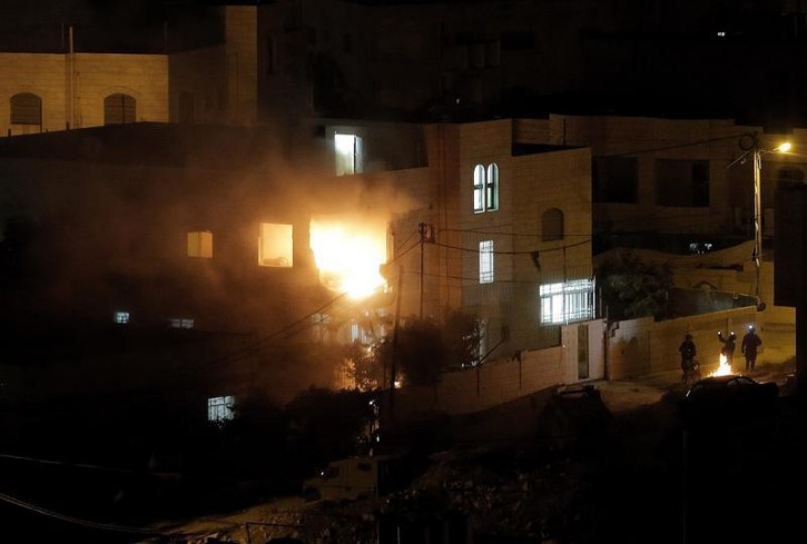 Flames are seen after a blast on the top floor of the family home of an alleged abductor in the West Bank City of Hebron July 1, 2014.  Reuters