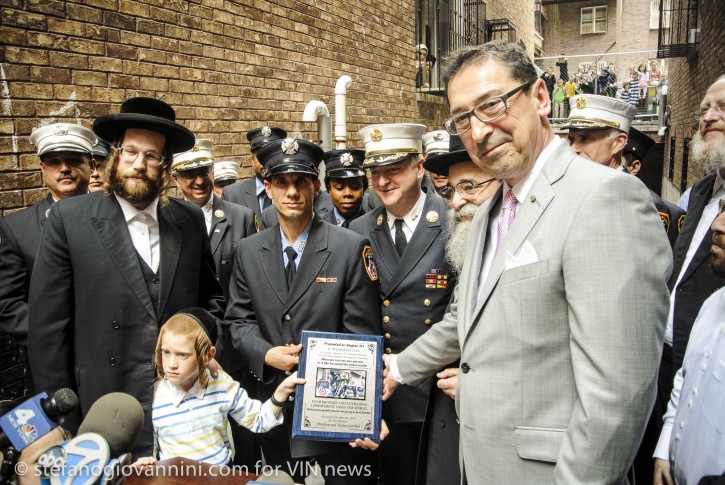 FDNY Commissioner Daniel Nigro receives a plaque from 7 year old Mendel Gottlib and his Father Avrham in Williamsburg Brooklyn NY on June 26, 2014.