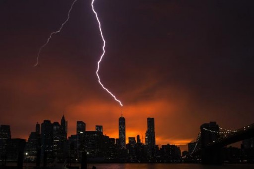 Lightning strikes One World Trade Center in Manhattan as the sun sets behind the city after a summer storm in New York July 2, 2014.  REUTERS/Lucas Jackson
