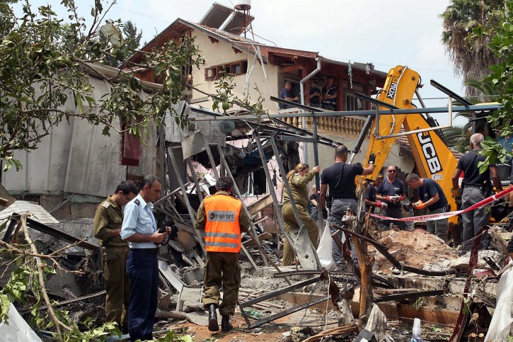  Israeli rescue and military personnel at the wreckage of a home in the town of Yehud, outside Tel Aviv, and near the Ben Gurion Airport, that was hit by a missile fired by Palestinian militants from inside the Gaza Strip, 22 July 2014.  EPA