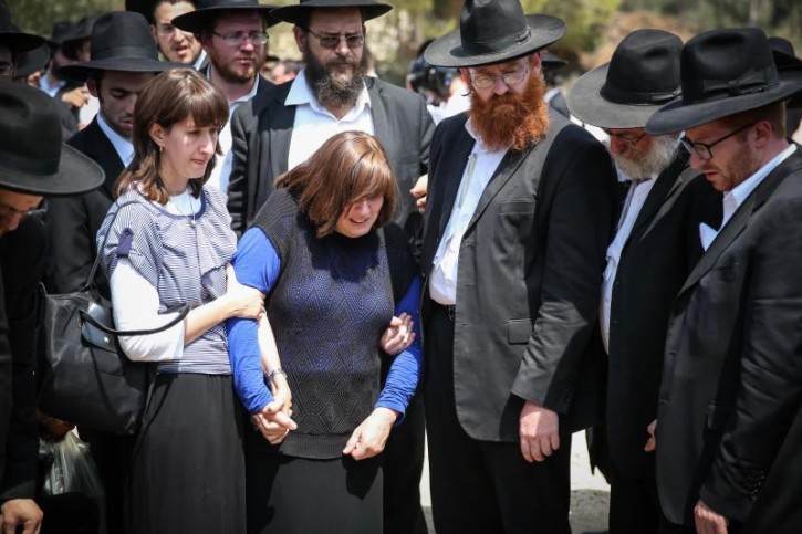 The mother and Family of Aharon Sofer mourn over his grave during his funeral procession at Etz Chaim cemetery in the city of Beit Shemesh on August 29, 2014. Sofer, 23, has gone missing since last Friday after hiking in the forest, his body found yesterday near the Jerusalem Forest. Flash90