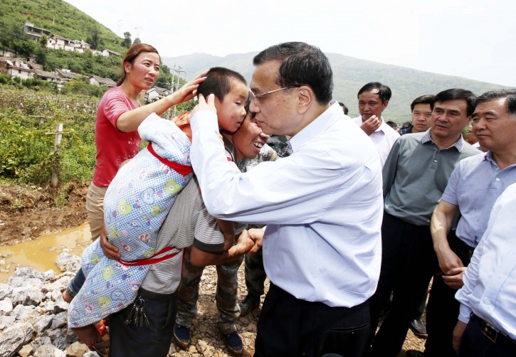 Chinese Premier Li Keqiang comforts a child at the earthquake zone in southwest China's Yunnan Province, Aug. 4, 2014. Premier Li Keqiang walked into Longtoushan Township of Ludian County Monday to examine the situation of the earthquake and instruct the quake relief work. (Xinhua/Yao Dawei) (yxb)