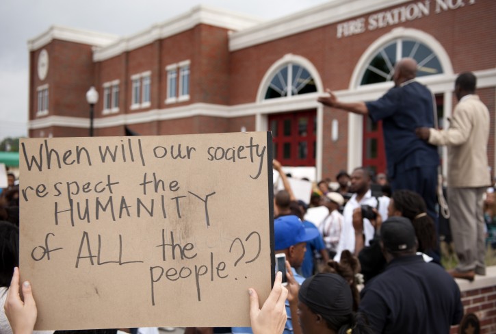 Protestors rally Sunday, Aug. 10, 2014 to protest the shooting of Michael Brown, 18, by police in Ferguson, Mo.  Saturday, Aug. 9, 2014. Brown died following a confrontation with police, according to St. Louis County Police Chief Jon Belmar, who spoke at a press conference Sunday. The protesters rallied in front of the police and fire departments in Ferguson following Belmar's press conference. (AP Photo/Sid Hastings)