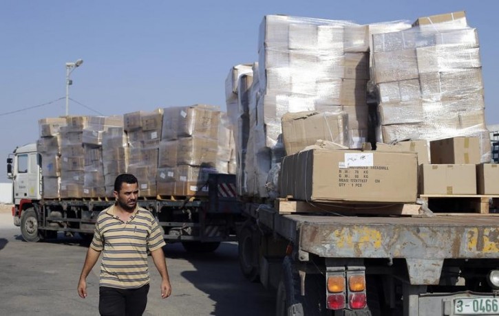 A Palestinian man walks next to a truck loaded with goods after entering Gaza at the Kerem Shalom crossing, in Rafah in the southern Gaza Strip August 28, 2014.