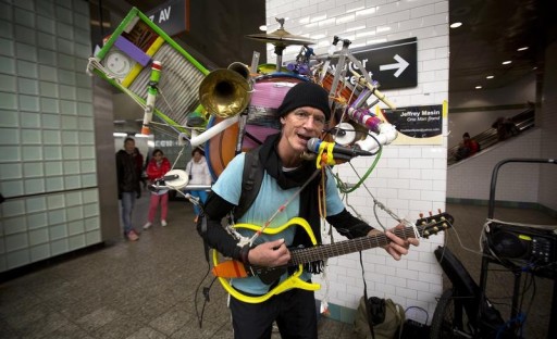 FILE - One-man band musician performs at the Times Square subway station for tips in New York, December 27, 2013.  