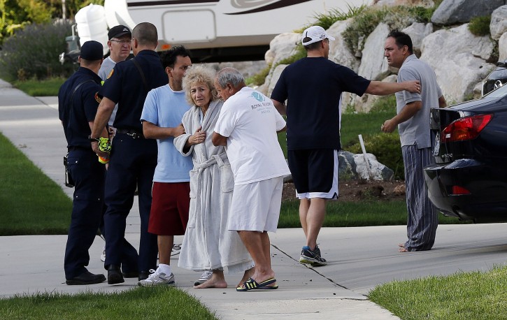 Residents are evacuated following a landslide in a hillside community of North Salt Lake, Utah, Tuesday, Aug. 5, 2014. One home has been destroyed and at least a dozen others have been evacuated.  (AP Photo/The Deseret News, Ravell Call) 