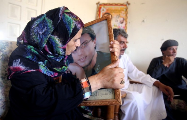 The mother of Palestinian Ahmed Asfour kisses his picture at her house in Khan Younis in the southern Gaza Strip September 17, 2014. REUTERS/Ibraheem Abu Mustafa