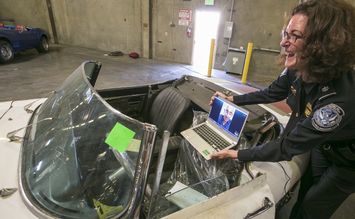 U.S. Customs and Border Protection, public affairs liaison chief, Lee Ann Harty, right, shows the interior of a classic British roadster, a 1967 Jaguar XK-E convertible that was stolen 46 years ago to his original owner, car collector Ivan Schneider via video conference in Carson, Calif., Wednesday, Sept. 17, 2014.  The car was recovered at the Port of Long Beach by the California Highway Patrol along with four other cars in a container en route to the Netherlands. (AP Photo/Damian Dovarganes)
