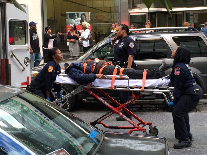 A second victim who was knocked to the ground by the fleeing perp is being wheeled into an ambulance. Photo by Samantha Samel