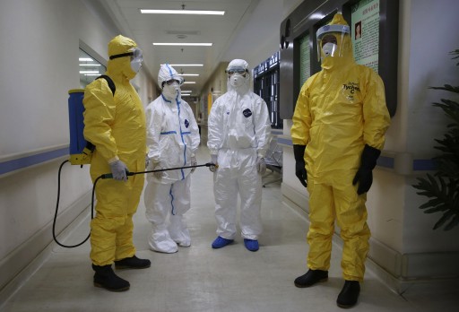 File: Health workers in protection suits wait in the corridor near a quarantine ward October 16, 2014. REUTERS/Stringer