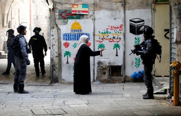 A Palestinian woman gestures towards an Israeli policeman in Jerusalem's old city October 30, 2014. REUTERS/Finbarr O'Reilly
