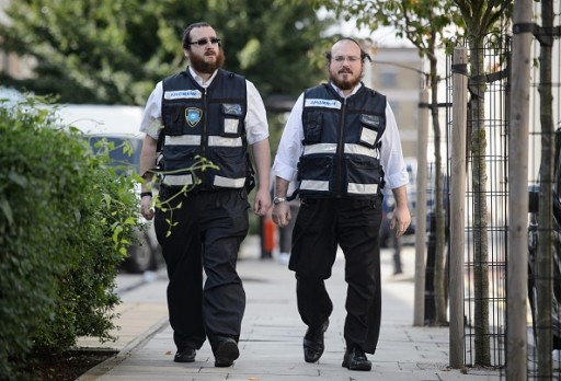 Members of the Jewish "Shomrim" security patrol team are pictured in north London on August 27, 2014. The unusual sight of crime-fighting Orthodox Jews pounding the streets of a tough London neighbourhood after dark has captured the attention of grateful locals, but their ongoing protection of local Muslims has seen their profile go global. AFP PHOTO/Leon Neal       