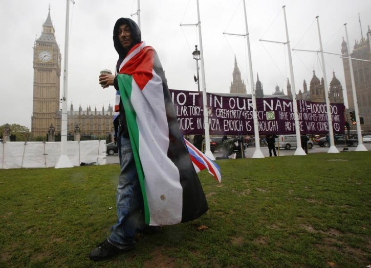 A pro-Palestine supporter wears a Palestinian and Union flag outside the Houses of Parliament in London October 13, 2014.  Reuters