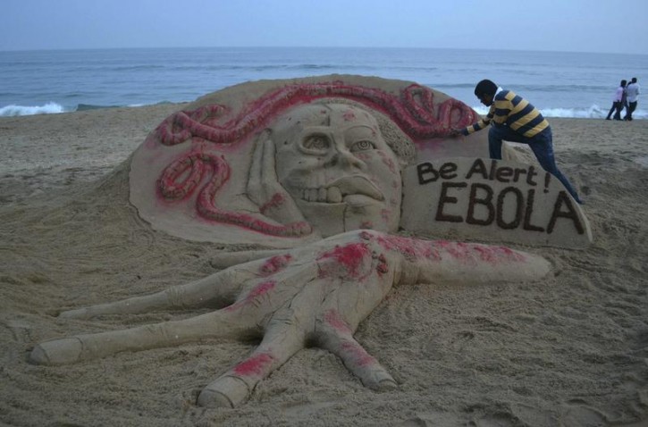 Indian sand artist Sudarshan Pattnaik works on a sand sculpture depicting a message on Ebola on a beach at Puri in the eastern Indian state of Odisha October 17, 2014. REUTERS/Stringer 