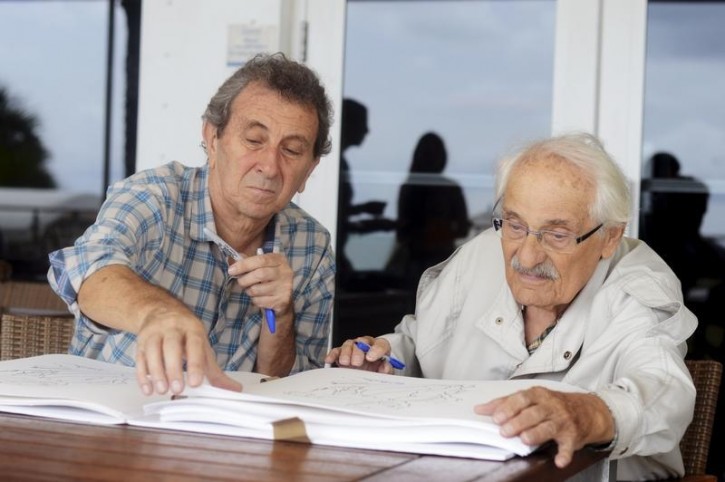 Samuel Willenberg, 92, the last known survivor of the Nazi extermination camp Treblinka in Poland and the subject of a film on the camp produced by Alan Tomlinson (L), signs sketches of one of his sculptures of scenes at Treblinka, in Miami Beach, Florida October 23, 2014. Willengberg began creating the sketches, which he recalls from his memory there, at the age of 70 after he retired. REUTERS/Zachary Fagenson