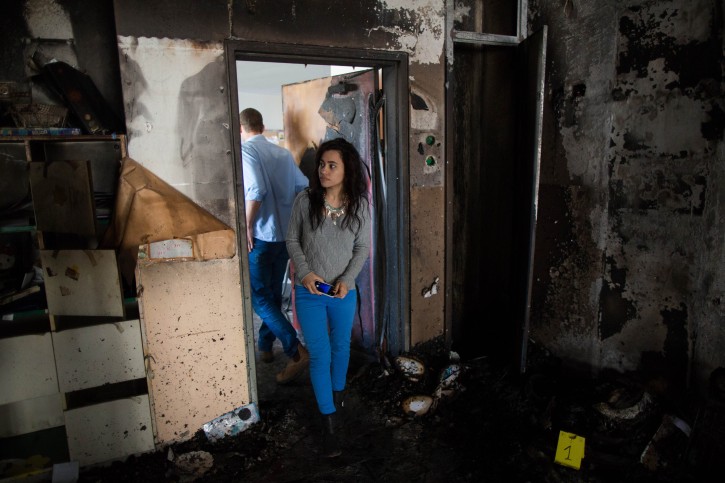 Israelis walk at the scene of where arsonists set fire a class in the bilingual Hebrew-Arabic school in Jerusalem and wrote Graffiti on the walls reading "death to Arabs" and referencing a late American-Israeli ultranationalist rabbi. November 30, 2014. Photo by Yonatan Sindel/Flash90 