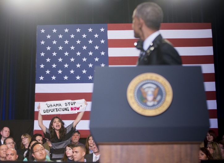 President Barack Obama turns around as he is interrupted by a woman on stage during his remarks at the Copernicus Community Center in Chicago to discuss immigration reform, Tuesday, Nov. 25, 2014. Obama visited his hometown to promote his executive action on immigration. (AP Photo/Pablo Martinez Monsivais)