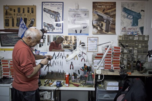 An Israeli weapon shop owner works at a repair corner of his shop in Jerusalem, Israel, 23 November 2014. EPA