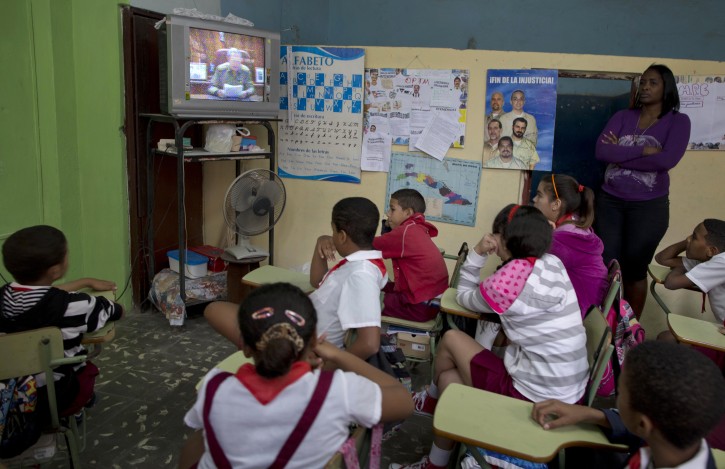 Students watch a live, nationally broadcast speech by Cuba's President Raul Castro about the country's restoration of relations with the United States, on a TV at school in Havana, Cuba, Wednesday, Dec. 17, 2014. Castro said profound differences remain between Cuba and the U.S. in areas such as human rights, foreign policy and questions of sovereignty, but that the countries have to learn to live with their differences "in a civilized manner." (AP Photo/Ramon Espinosa)