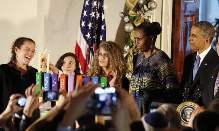 U.S. President Barack Obama (R) is joined by (L-R) Rebecca Bardach, Inbar Shaked Vardi, Mouran Ibrahim and first lady Michelle Obama as they attend a Hanukkah reception in the Grand Foyer of the White House in Washington, December 17, 2014.        REUTERS/Larry Downing