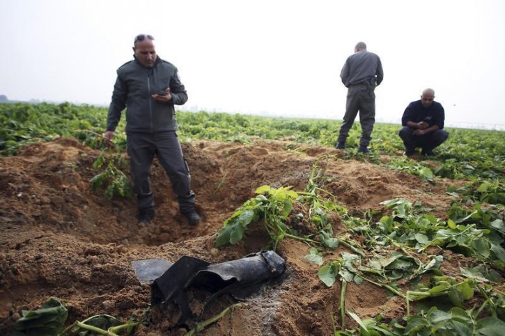 Israeli security forces stand next to the remains of a rocket that was fired from the Gaza Strip towards Israel on Friday, on the Israeli side of the border December 19, 2014. The military said it was the third rocket fired from Gaza since the end of the July-August conflict. No Palestinian group claimed responsibility for the attack.   REUTERS/Ilan Assayag