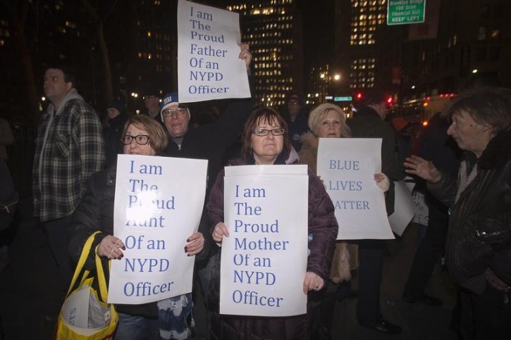 Protester hold signs supporting the NYPD during a rally in Manhattan, New York December 19, 2014. Decisions by grand juries to return no indictments against the officers involved in the deaths of Michael Brown in Missouri and Eric Garner in New York have put police treatment of minorities back on the national agenda.            REUTERS/Carlo Allegri 
