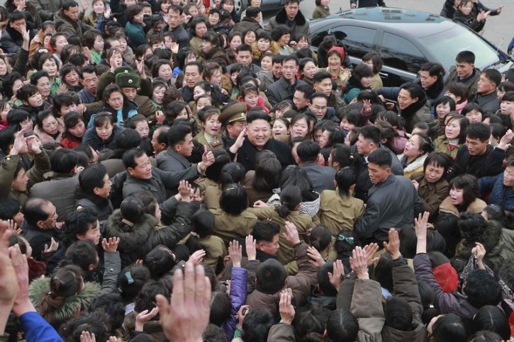 North Korean leader Kim Jong Un (C) smiles as a huge crowd surrounds him while he gives field guidance at the Kim Jong Suk Pyongyang Textile Mill in this undated photo released by North Korea's Korean Central News Agency (KCNA) in Pyongyang December 20, 2014.   REUTERS/KCNA