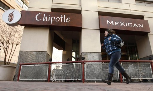FILE - A woman runs past a Chipotle Mexican restaurant . Reuters