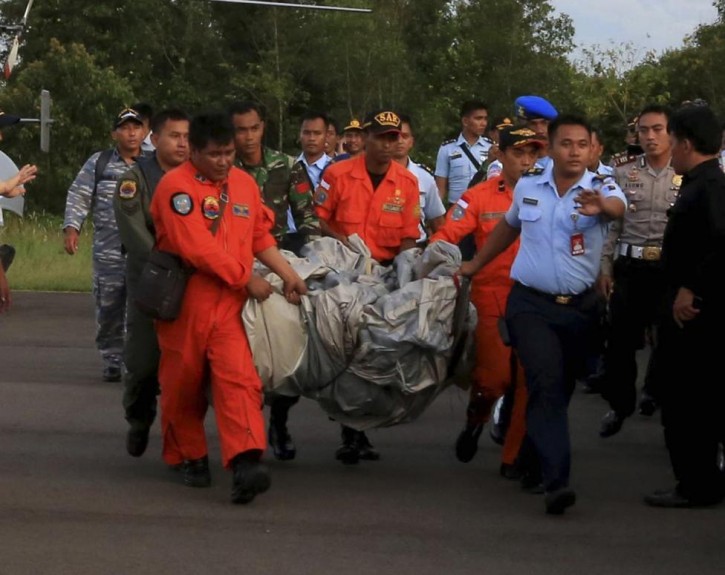 Members of the Search and Rescue Agency SARS carry debris recovered from the sea presumed from missing Indonesia AirAsia flight QZ 8501 at Pangkalan Bun, Central Kalimantan, December 30, 2014.  REUTERS/Antara Foto/Kenarel