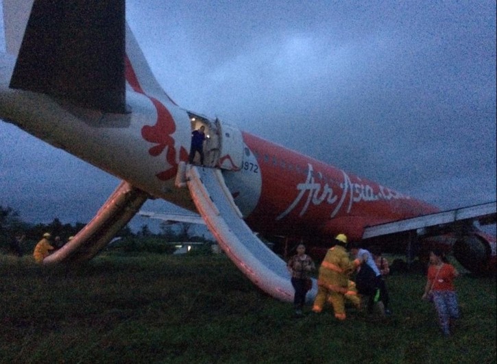 A handout photo provided by Rappler.com shows Filipino rescuers assisting passengers disembark through an emergency slide at the rear end of the AirAsia plane after it overshot landing in Kalibo, Aklan, central Visayas, Philippines, 30 December 2014. EPA