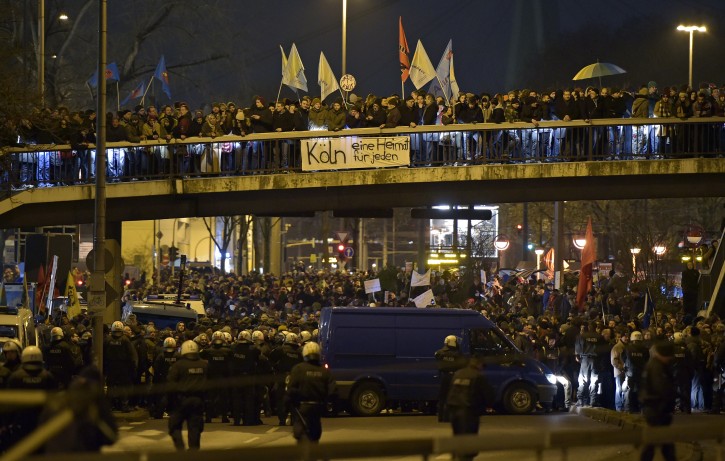 Thousands of people demonstrate against a rally called 'Patriotic Europeans against the Islamization of the West' (PEGIDA) in Cologne, Germany, Monday evening, Jan. 5, 2015. A banner reads "Cologne is a home for everyone". The PEGIDA  march through the city was stopped by the counter-demonstration. (AP Photo/Martin Meissner)