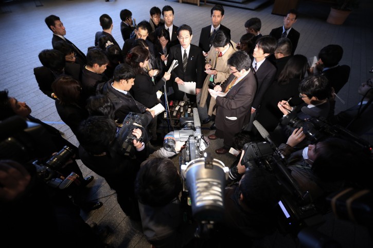 Japanese Foreign Minister Fumio Kishida, center top, surrounded by journalists is asked on Japanese journalist Kenji Goto taken hostage by the Islamic State group, at the prime minister's official residence in Tokyo, Friday, Jan. 30, 2015. (AP Photo/Eugene Hoshiko)