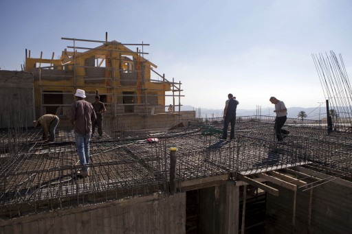 FILE - In this Sept. 16, 2014 file photo, Palestinians laborers work at a construction site in the Jewish West Bank settlement of Maale Adumim, near Jerusalem. (AP Photo/Dan Balilty)