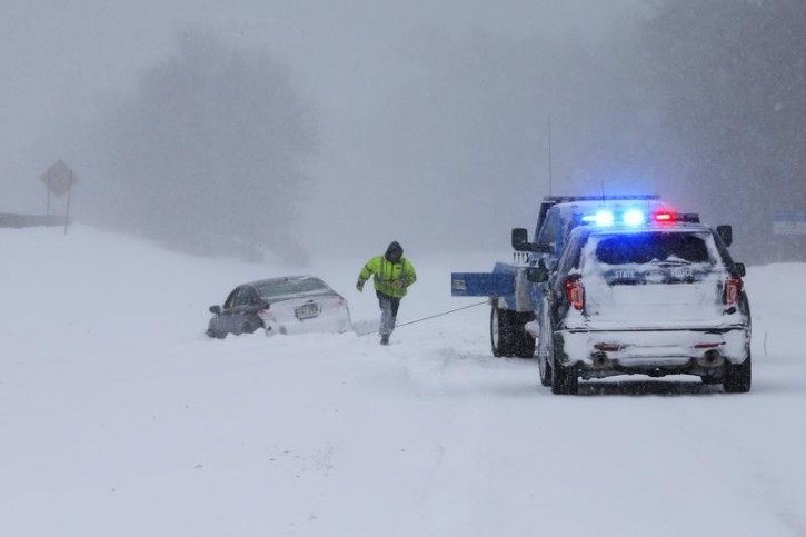 A tow truck operator works to pull a car out of the snow in the median and back onto Route 3 during a winter blizzard in Hingham, Massachusetts January 27, 2015.    REUTERS/Brian Snyder 