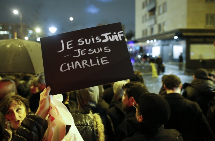  A sign reading 'I am Jewish, I am Charlie' is held up as people come to pay tribute to the hostage victims in front of HyperCacher supermarket at Porte de Vincennes, a day after a gunman took hostages and opened fire, in eastern Paris,  France, 10 January 2015. EPA