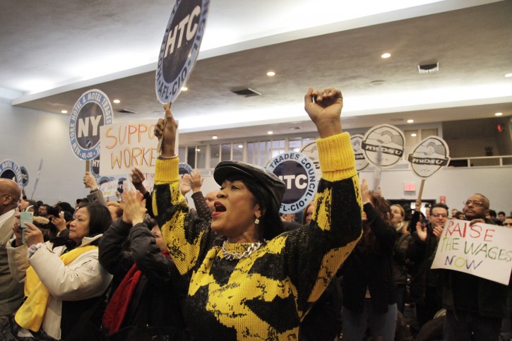 Desiree Norris, center, and union members of the Hotel and Motel Trades Council cheer during a speech by New York governor Andrew Cuomo, Tuesday, Feb. 24, 2015 in New York.  The Cuomo administration announced Tuesday that restaurant servers, hotel housekeepers and other tipped workers in New York will soon make $7.50 an hour before tips, a change that will translate into a big raise for thousands of workers throughout the state. Norris works as a housekeeper for the St. Regis Hotel in the city. (AP Photo/Mark Lennihan)