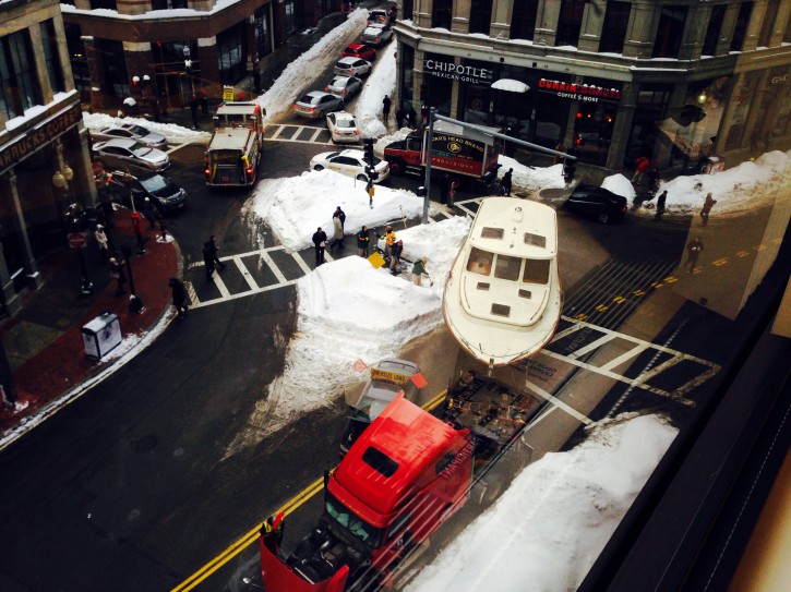 In this photo taken through a window provided by Jen Grygiel, a large truck towing an even bigger boat broke down in downtown Boston, snarling traffic in the heart of the city's Financial District on Wednesday, Feb. 11, 2015. WCVB-TV (AP Photo/Jen Grygiel)