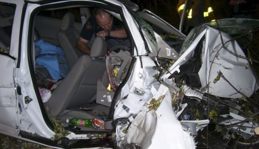 A Wisconsin State Patrol police officer looks through the wreck of a 2005 Chevy Cobalt in this October 24, 2006 file photo.  REUTERS/St Croix Sherriff