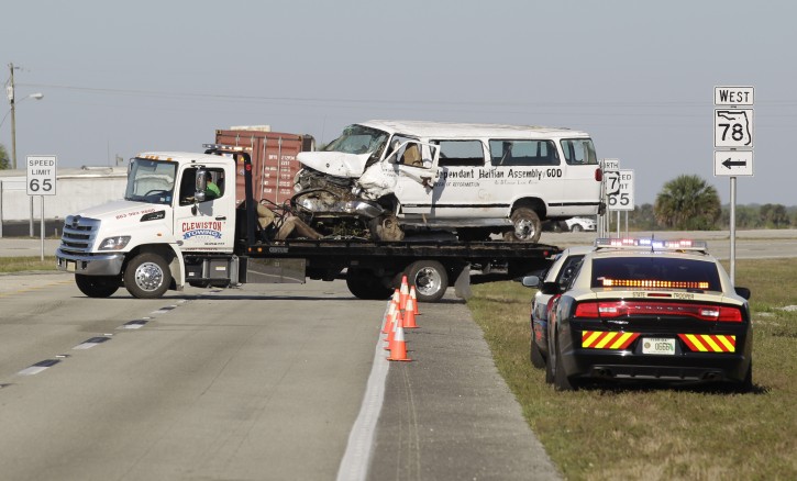 A tow truck moves a  van that crashed into a canal at the intersection of US 27 and State Road 78 West, Monday, March 30, 2015, near Moore Haven, Fla. Eight people were killed and 10 injured when the church van ran through a stop sign, crossed all four lanes of a rural highway and crashed into in a canal.  (AP Photo/Luis M. Alvarez)