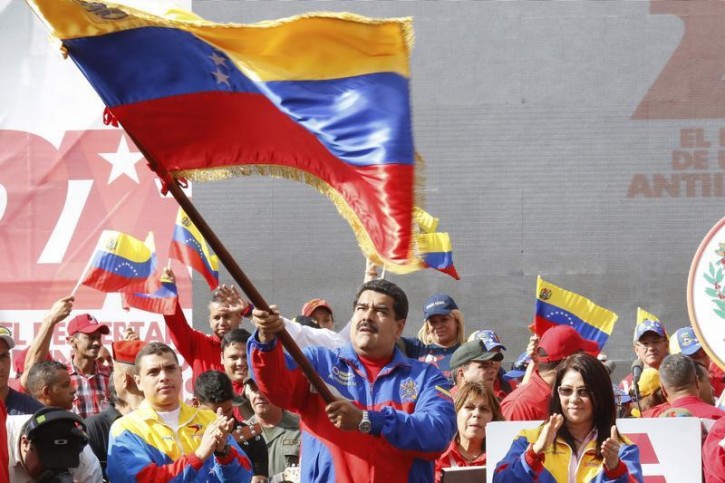 Venezuela's President Nicolas Maduro (C) waves a Venezuelan flag during a rally to commemorate the 26th anniversary of the social uprising known as 'Caracazo', which Venezuela's late President Hugo Chavez said marked the start of his revolution, in Caracas in this February 28, 2015 handout picture provided by Miraflores Palace.  Reuters