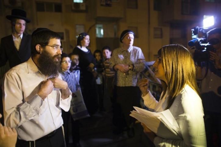 Ruth Colian (R), head of B'Zchutan, Israel's first ultra-Orthodox Jewish women's party, speaks with an ultra-orthodox man as she campaigns in Beit Shemesh, near Jerusalem March 10, 2015.  B'Zchutan, which means "thanks to them" in Hebrew, refers to Ultra-Orthodox Haredi women who have chosen to confront their religious community's traditional beliefs about women's role and place in the modern Israeli society. Picture taken March 10, 2015. REUTERS/Ronen Zvulun 