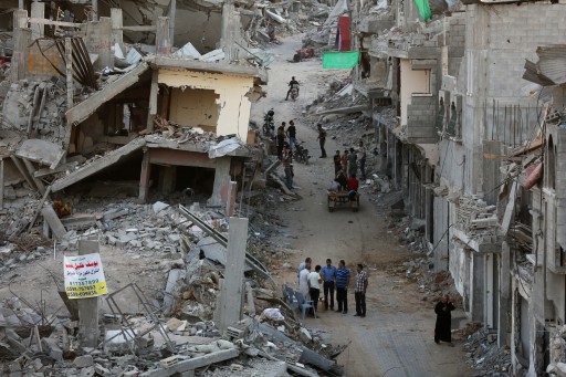 File: Palestinians meet between destroyed houses in the Al Shejaeiya neighborhood in the East of Gaza City, 10 September 2014. EPA/MOHAMMED SABER