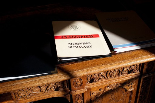 File: A document folder is framed by shadows on President Barack Obama's desk in the Oval Office. (Official White House Photo by Pete Souza)