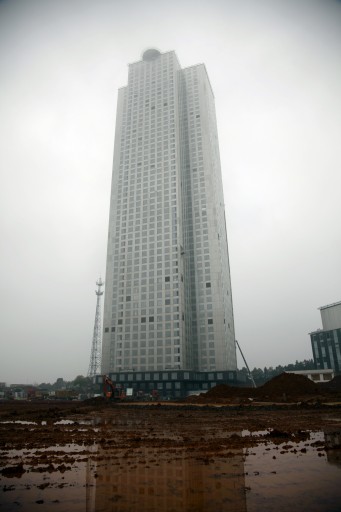 In this Thursday, March 19, 2015 photo, a puddle reflects the Mini Sky City building in Changsha in central China's Hunan Province. The Broad Sustainable Building Co., a Chinese construction firm, built the 57-story building in just 19 working days using a modular method, assembling three floors per day in what it considers the worldâs fastest construction speed. (AP Photo/Peng Peng)