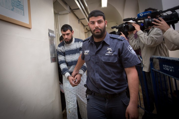 Police escort East Jerusalem resident Khaled Kutina to his hearing at the Magistrate's Court in Jerusalem. Kutina rammed his car into a bus stop in the Jerusalem neighborhood of French Hill last night, killing a young Israeli man and injuring a woman. Police are investigating the possibility that the incident may have been a terrorist attack. April 16, 2015. Photo by Miriam Alster/FLASH90 