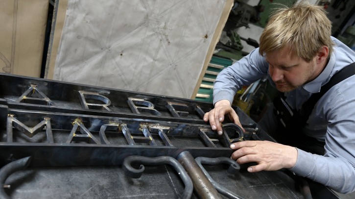 Blacksmith Michael Poitner works on a replica of the concentration camp gate with the Nazi slogan "Arbeit macht frei" (Work sets you free) in Biberbach near Dachau, Germany, Thursday, April 16, 2015. Unidentified people have stolen the main entrance gate in November 2014. (AP Photo/Matthias Schrader)