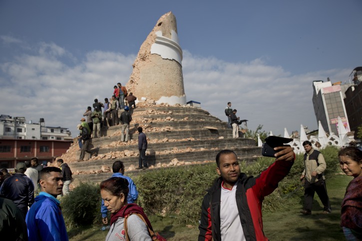 A man takes a selfie at the historic Dharahara Tower, a city landmark, that was damaged in Saturdays earthquake in Kathmandu, Nepal, Monday, April 27, 2015. A strong magnitude earthquake shook Nepals capital and the densely populated Kathmandu valley on Saturday devastating the region and leaving tens of thousands shell-shocked and sleeping in streets. (AP Photo/Bernat Armangue)